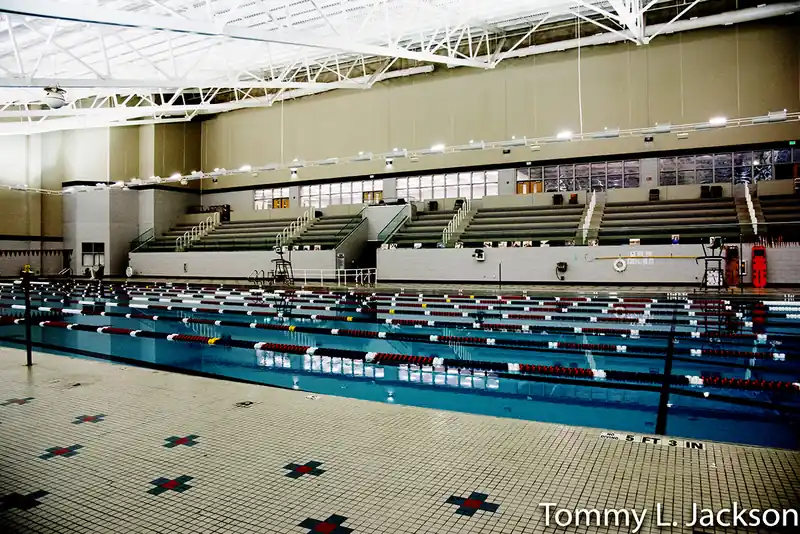 Lane ropes with red and white floats in front of tiered seating, with a 5 ft 3 in depth mark on the tiled deck
