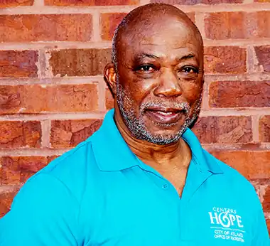 Head Coach Tommy Lee Jackson in front of a brick wall