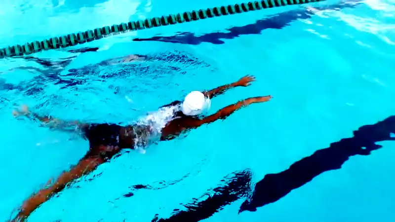 A swimmer mid-stroke seen from underwater