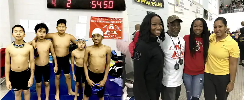 Young swimmers beside their coaches under a scoreboard reading 54.50